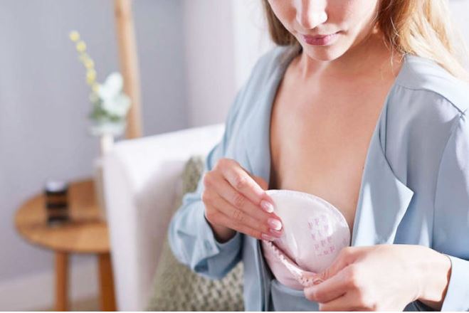 woman inserting breast pads