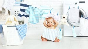 baby amongst washed clothes and clothing line