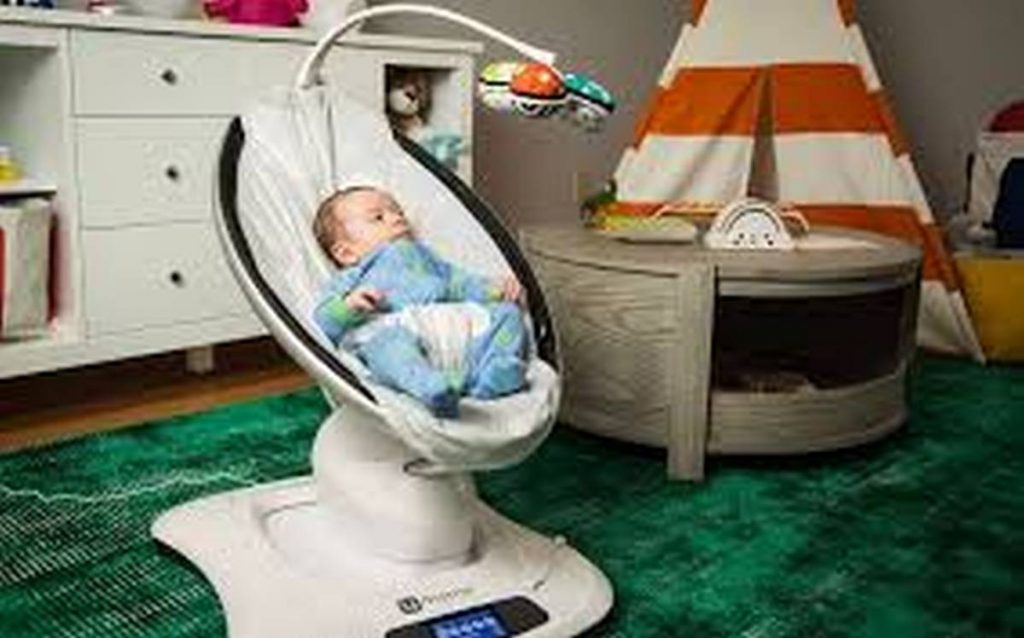 baby in baby bouncer with mobile attachment