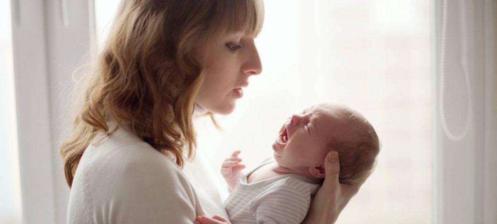 mum holding crying baby