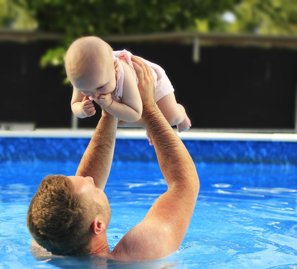 baby in the pool with father