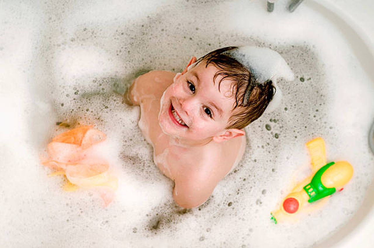 a baby in a bathtub with soap foam.