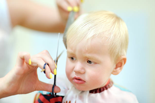 portrait of toddler child getting his first haircut
