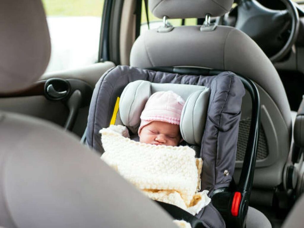 sleeping baby girl in baby car seat for babies and infants